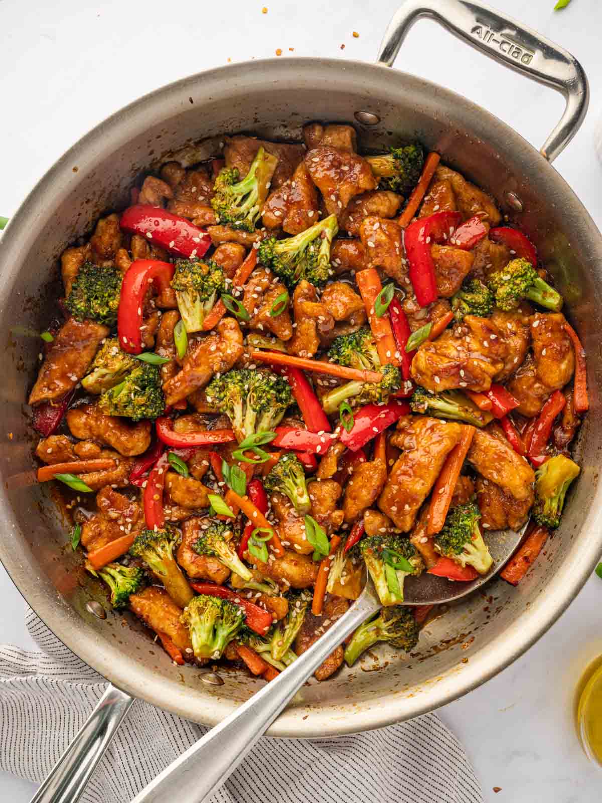 Hunan chicken recipe in a skillet with a spoon.