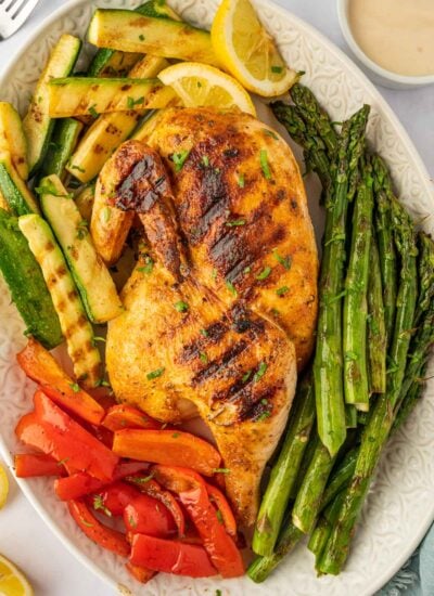 A grilled half chicken on a platter.
