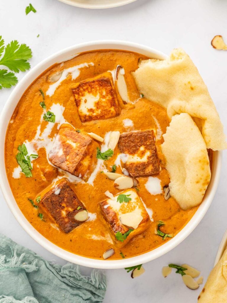 A bowl of paneer pasanda with naan.