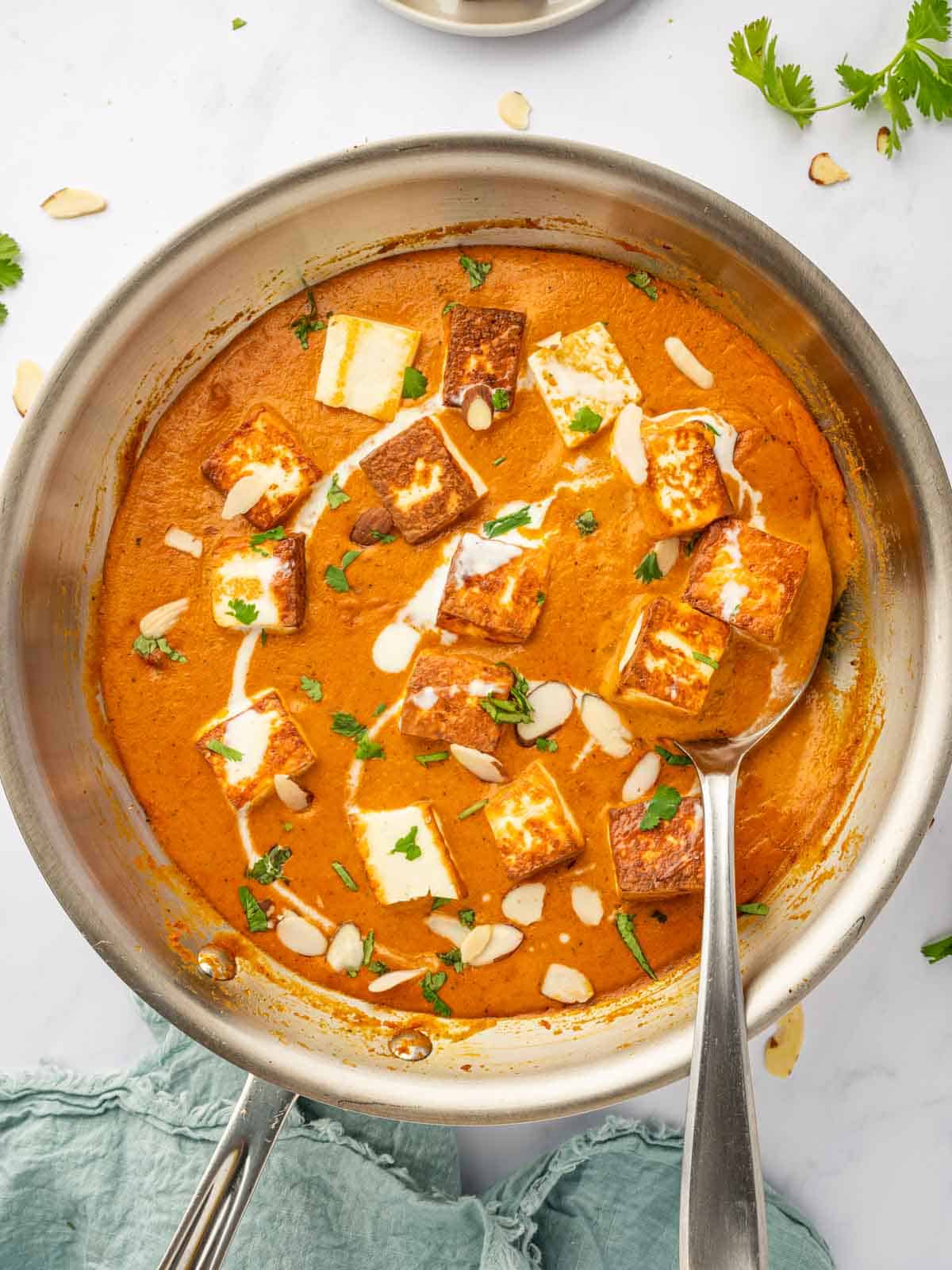 A spoon serves a helping of paneer pasanda.