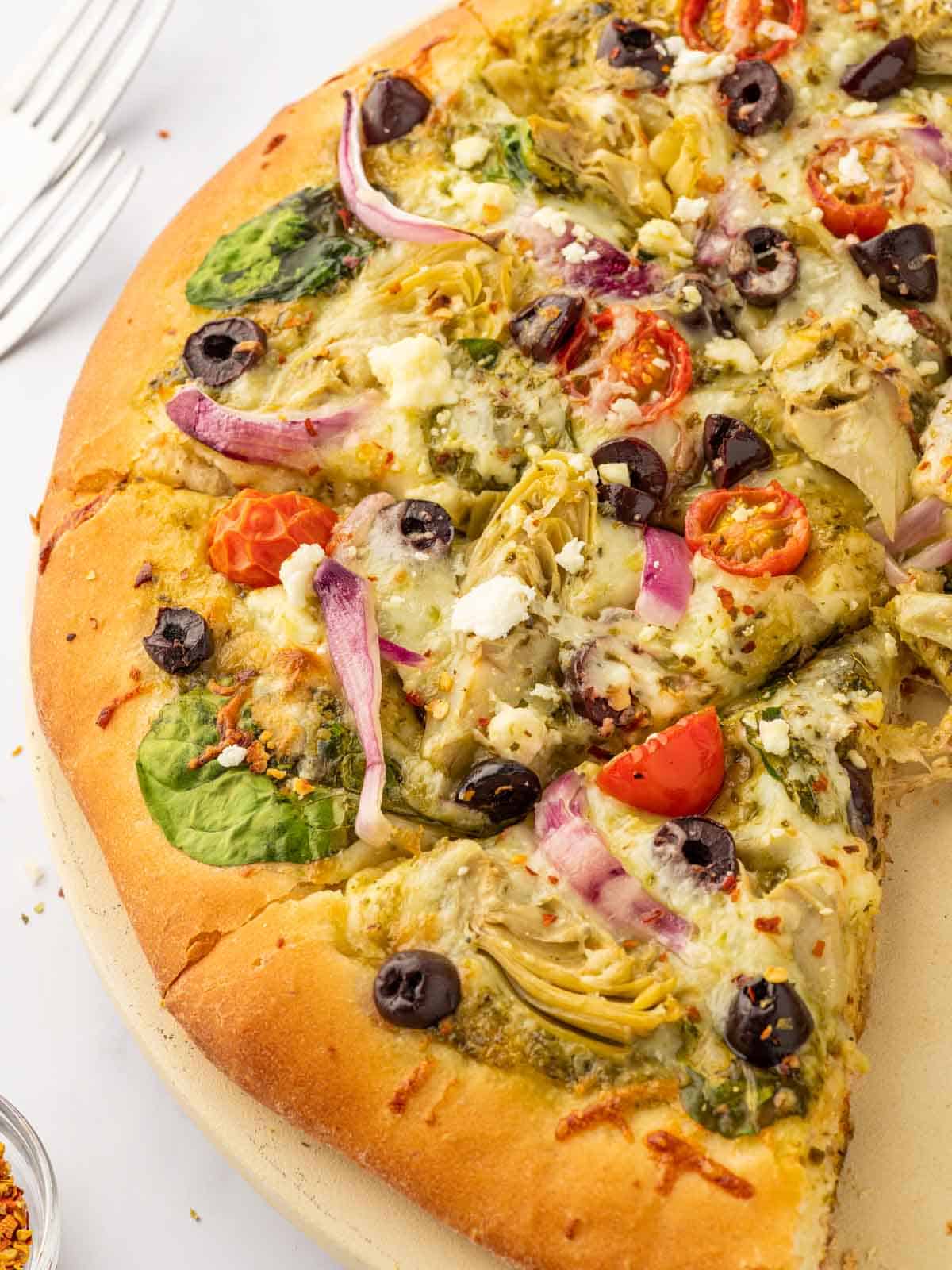 Close up of pizza with feta, artichokes and olives.