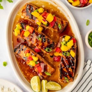 Grilled salmon on a plate topped with mango salsa.