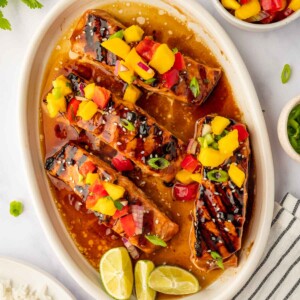 Grilled salmon on a plate topped with mango salsa.