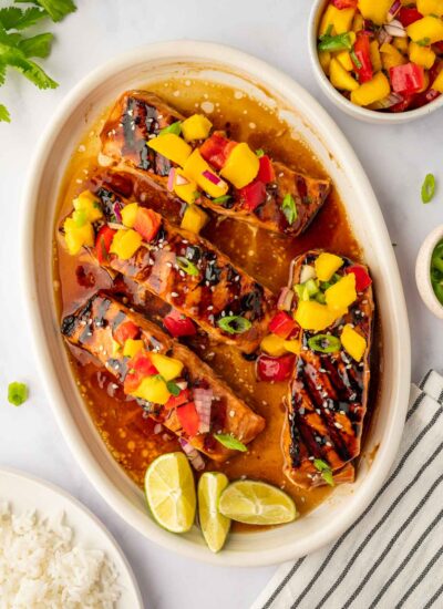 Grilled salmon on a plate topped with mango salsa.