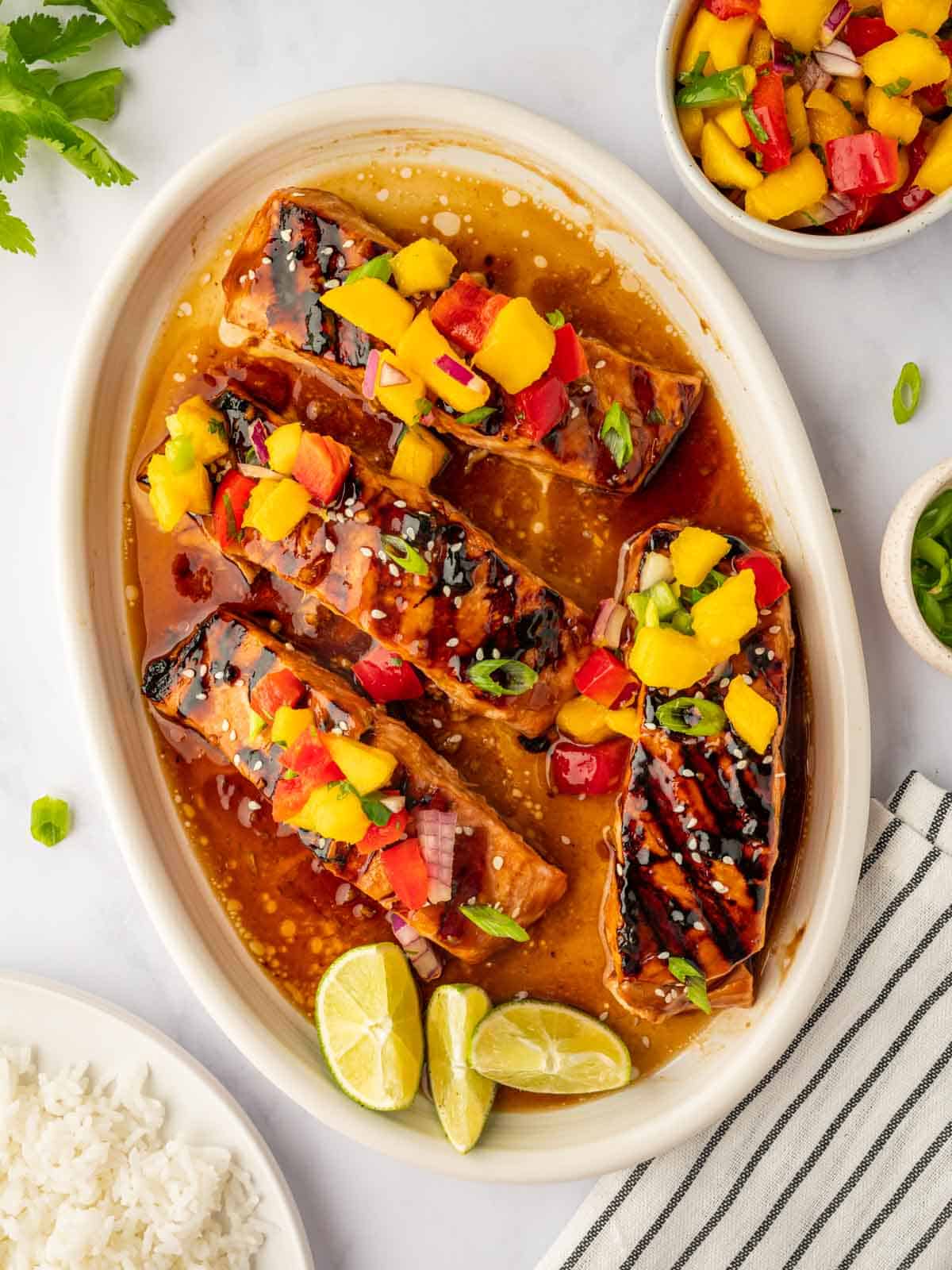 Grilled salmon on a plate topped with mango salsa.