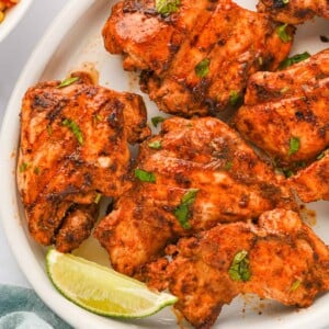 Pieces of Mexican grilled chicken thighs on a platter.