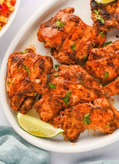 Pieces of Mexican grilled chicken thighs on a platter.