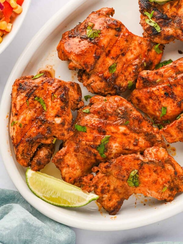 Pieces of Mexican grilled chicken thighs on a platter.