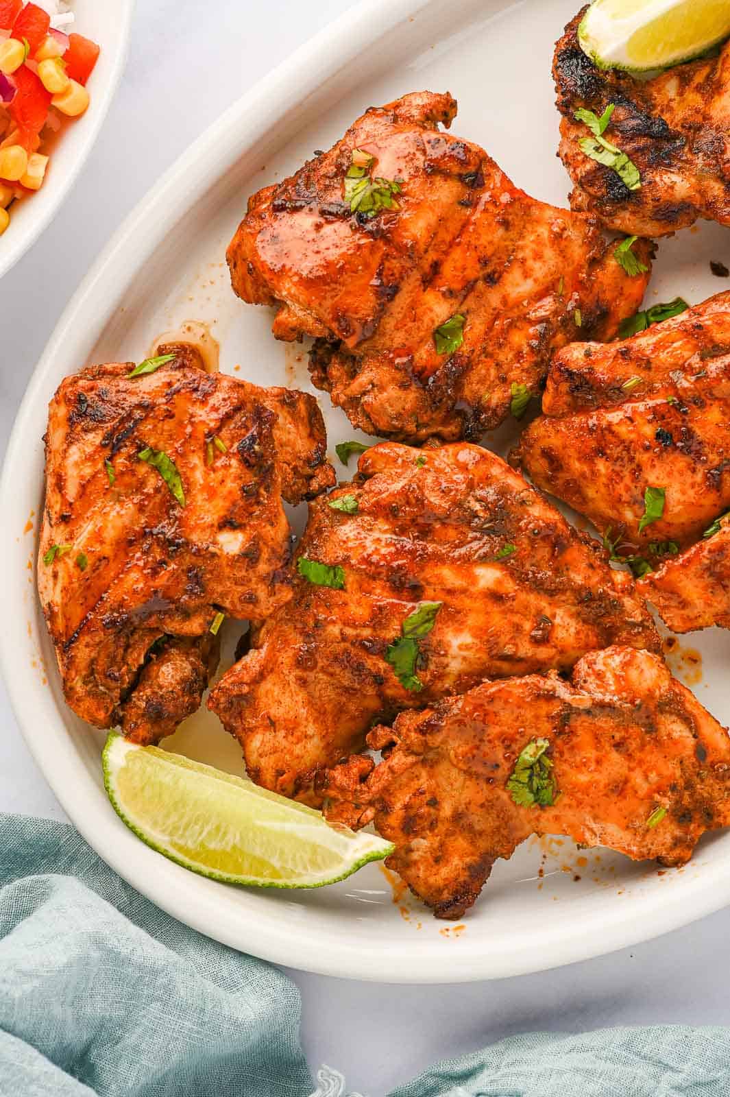 Pieces of Mexican grilled chicken thighs on a platter.