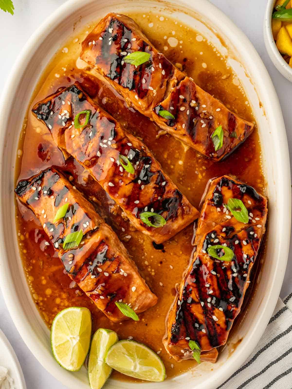 Grilled salmon teriyaki is garnished with green onions and sesame seeds.