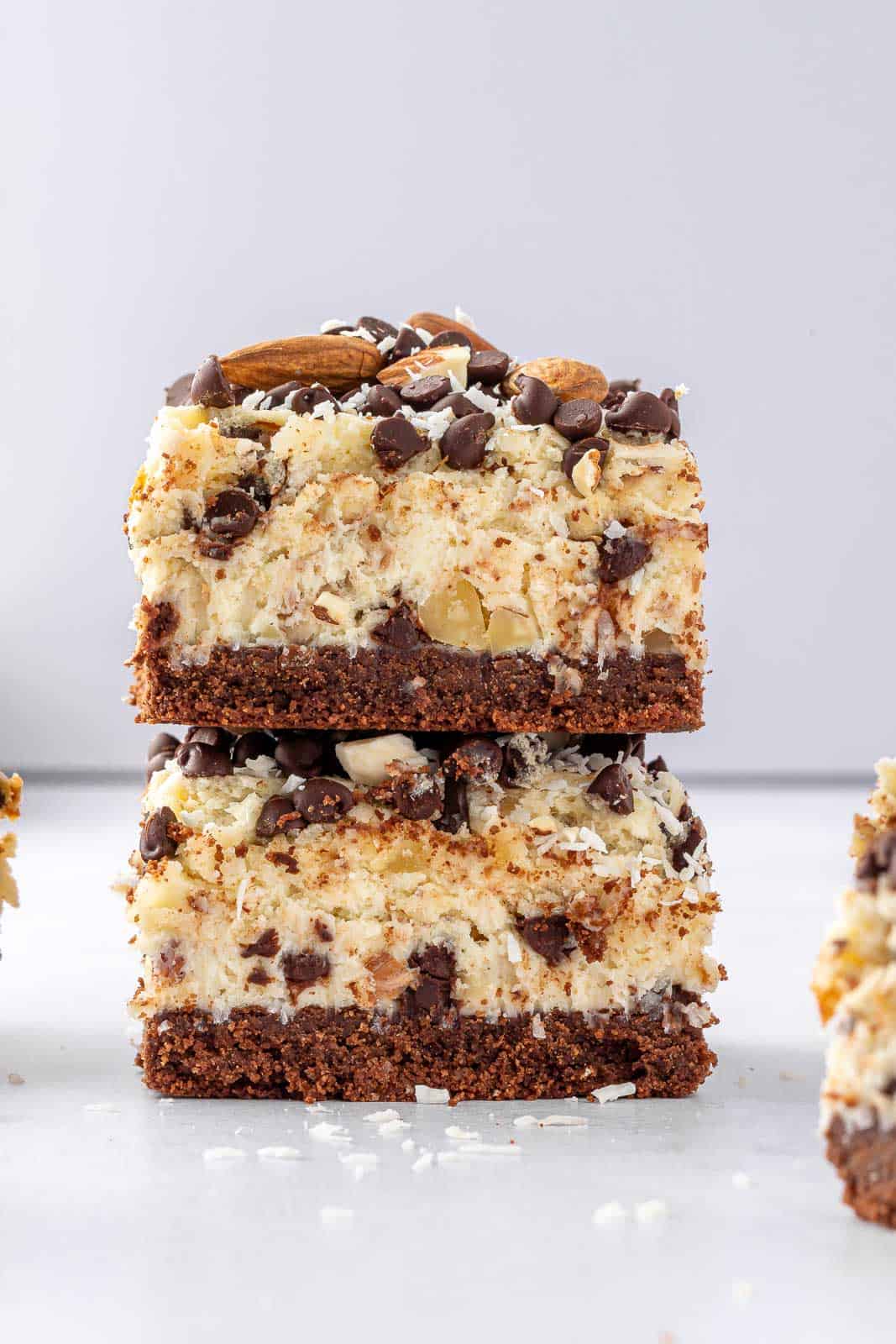 two bars of almond joy cheesecake bars stacked.