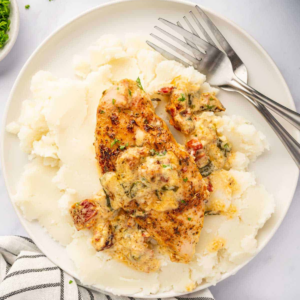 Seasoned chicken breast topped with creamy spinach and sun-dried tomato sauce, served on mashed potatoes.