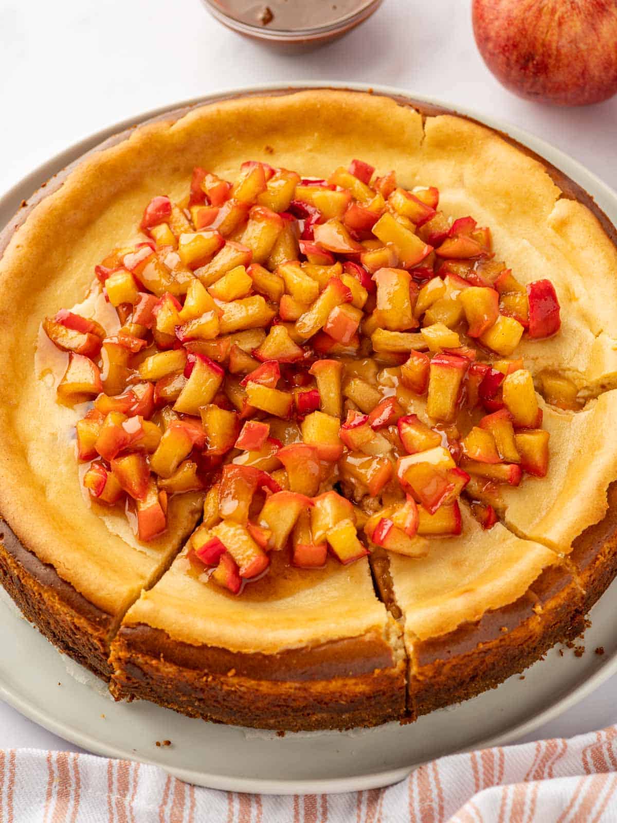 A whole cheesecake topped with cinnamon apples.