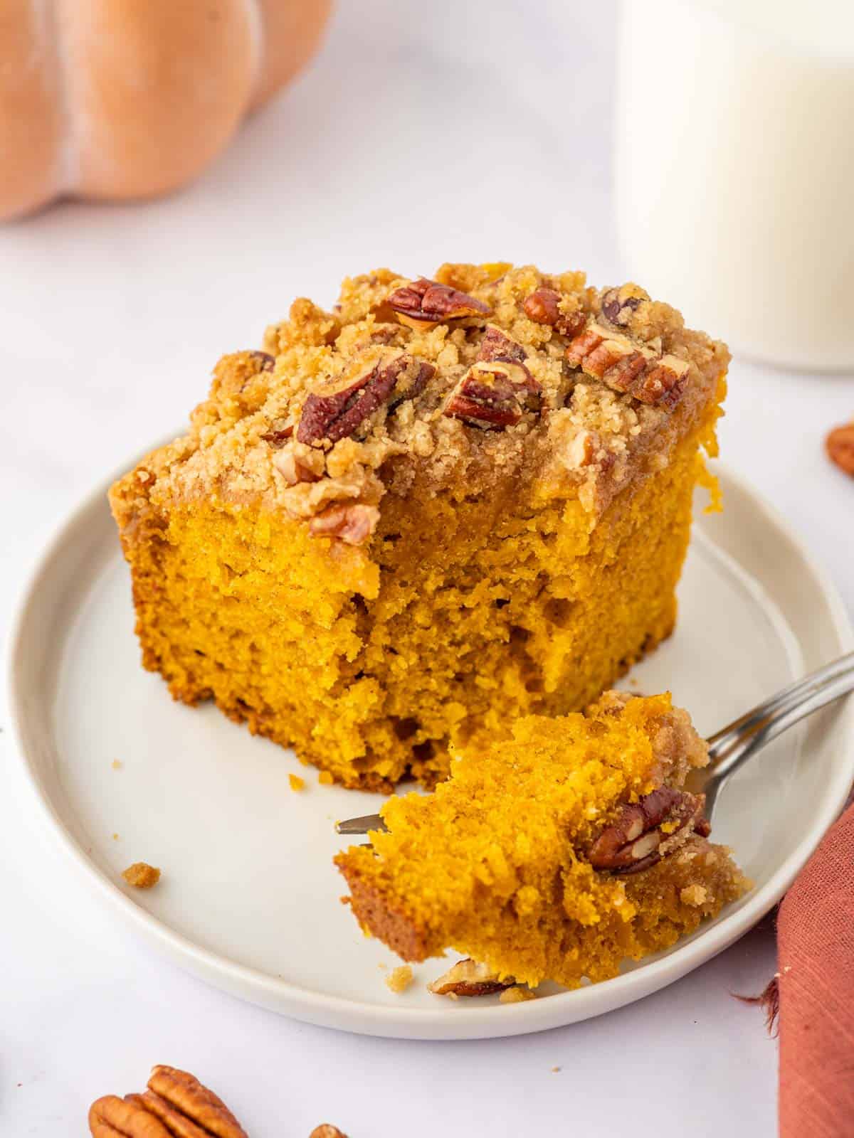 A fork breaks off a bit of pumpkin pecan coffee cake.