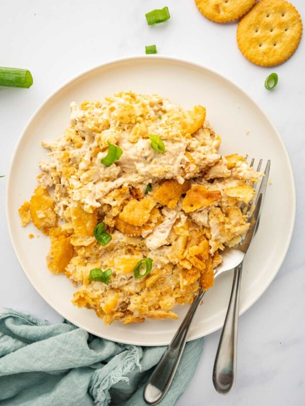 A portion of million dollar chicken is on a plate with 2 forks.