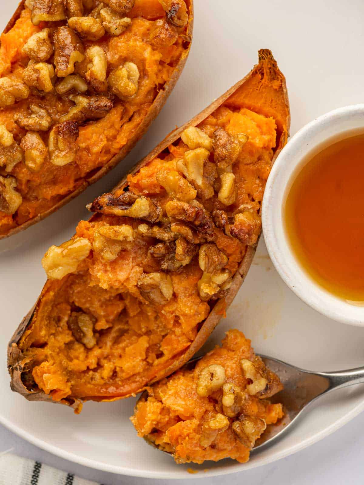 A spoon scoops a bite of sweet potatoes.