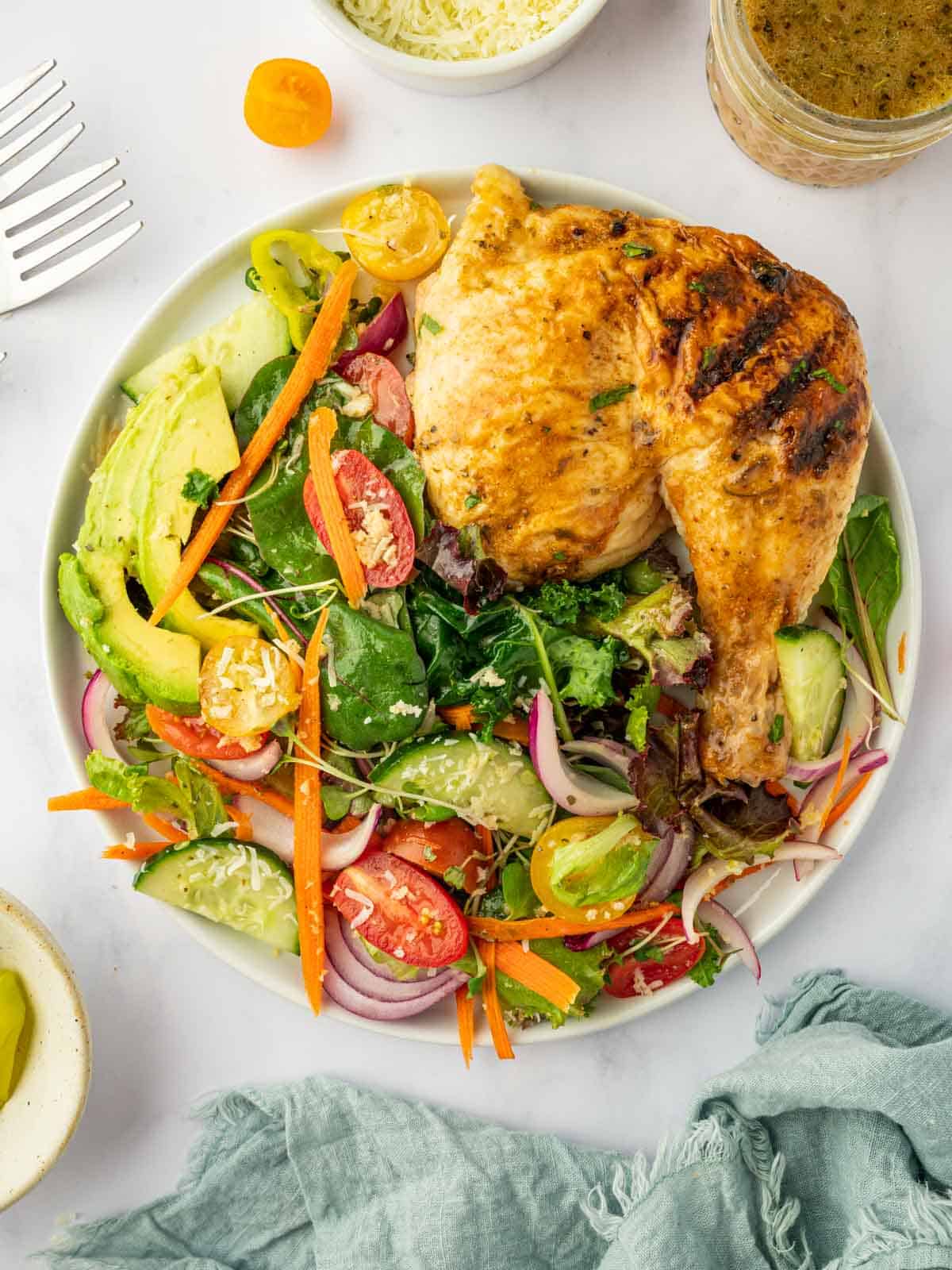 Traditional house salad served with chicken on a plate.