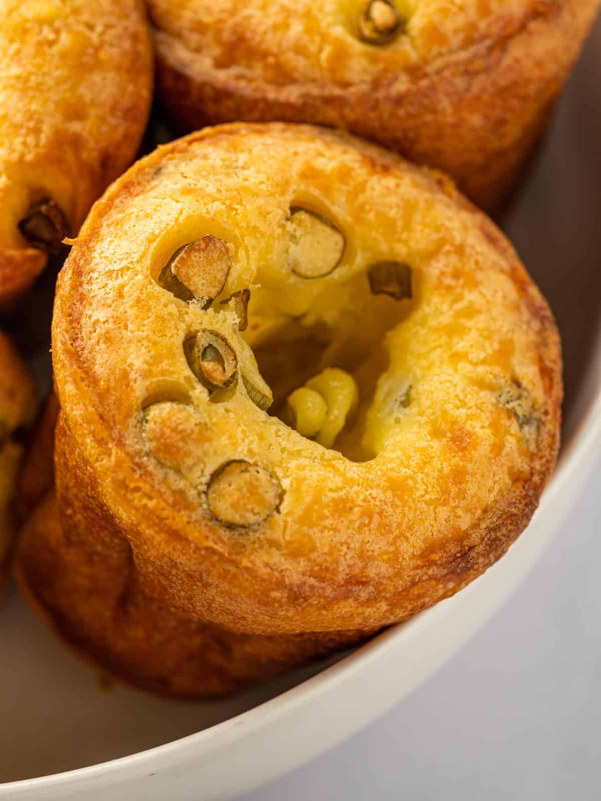 Golden brown cheese popover topped with sliced green onions.