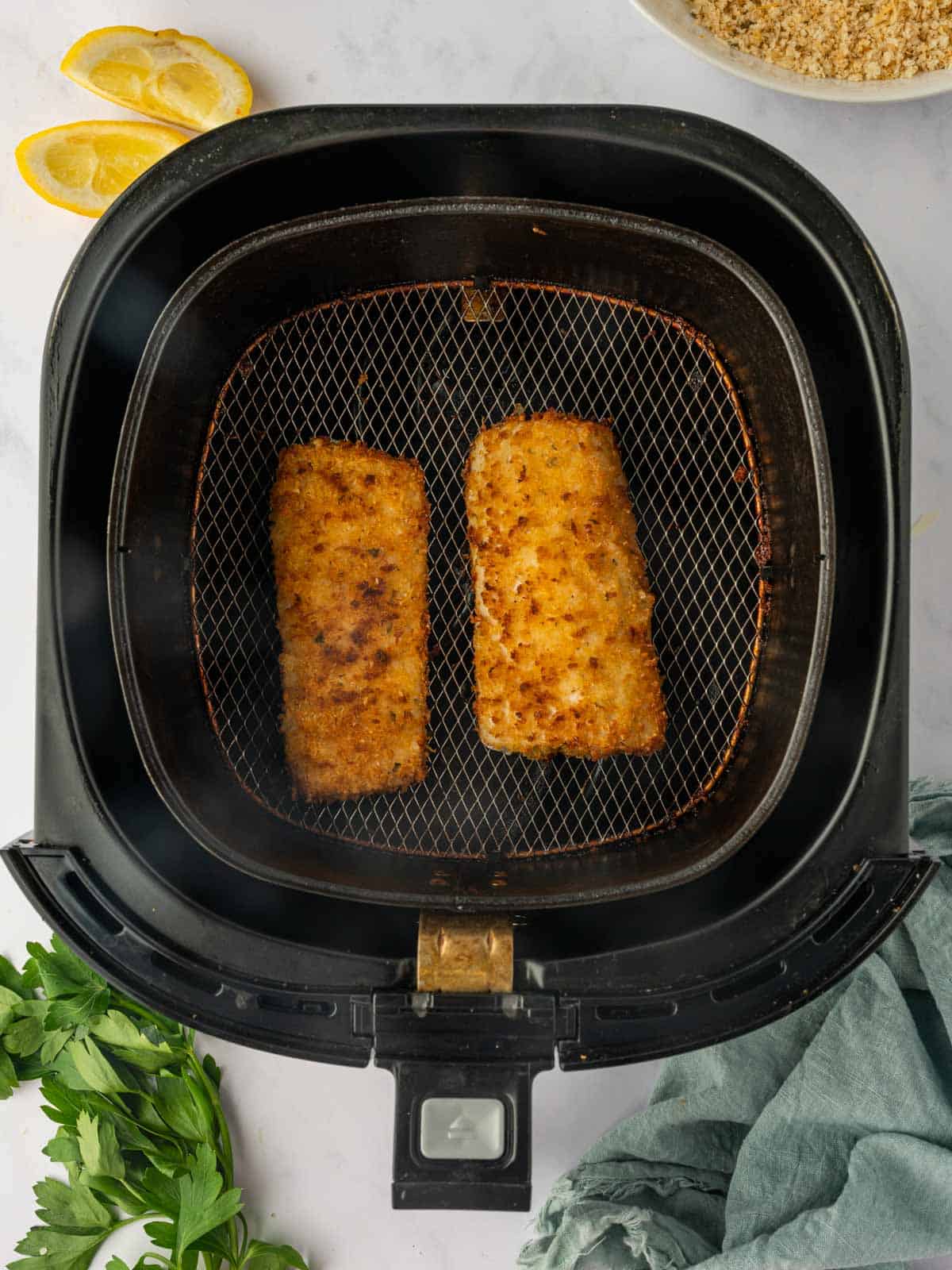 Breaded Mahi Mahi fish in the air fryer after cooking.