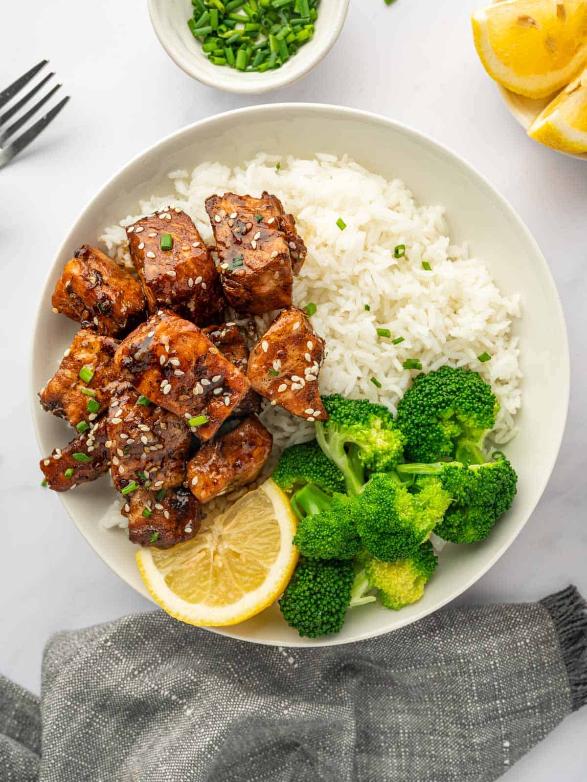 Cubes of tender salmon are served on a plate with rice.