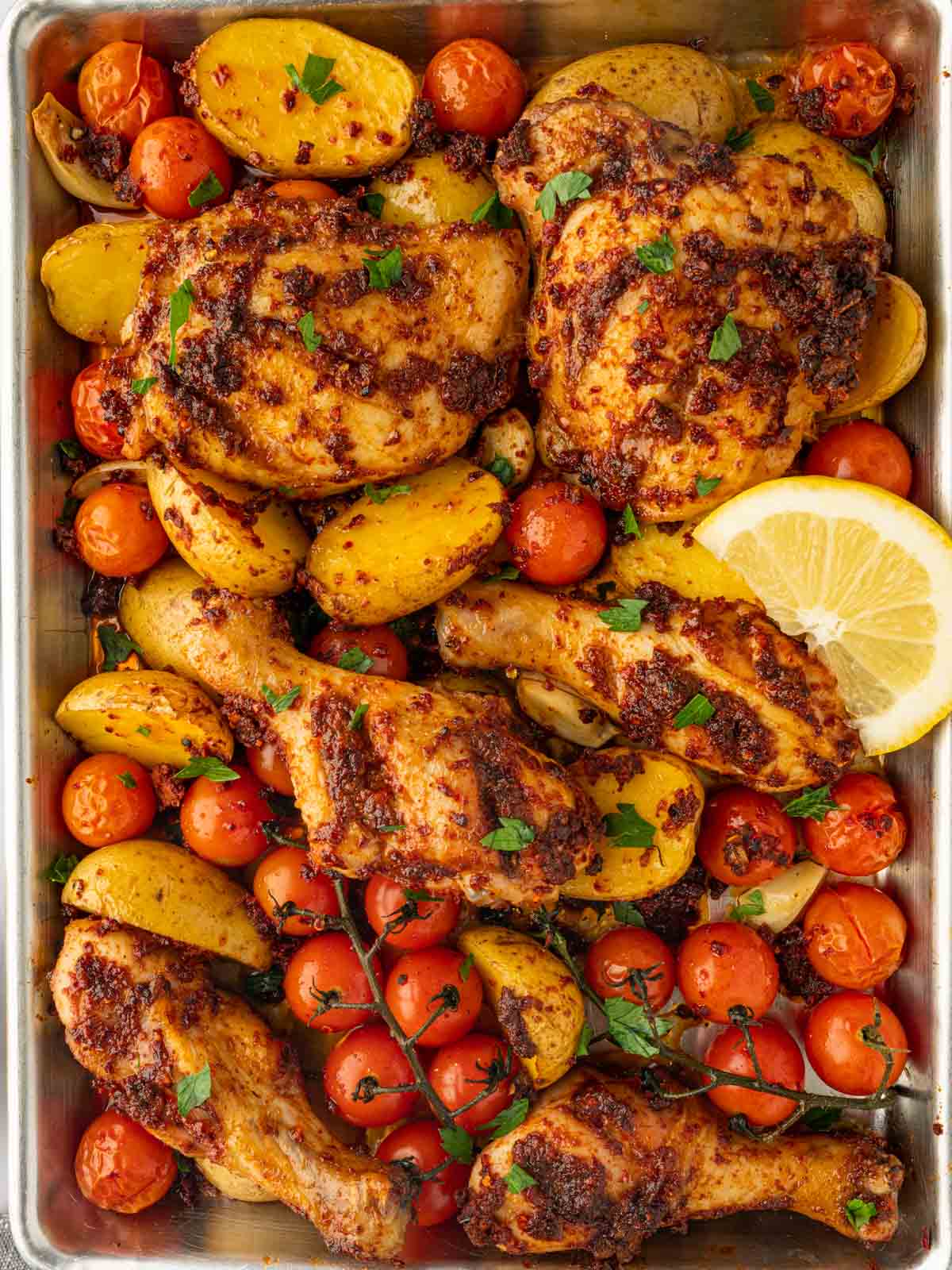 Chicken with harissa baked on a tray.