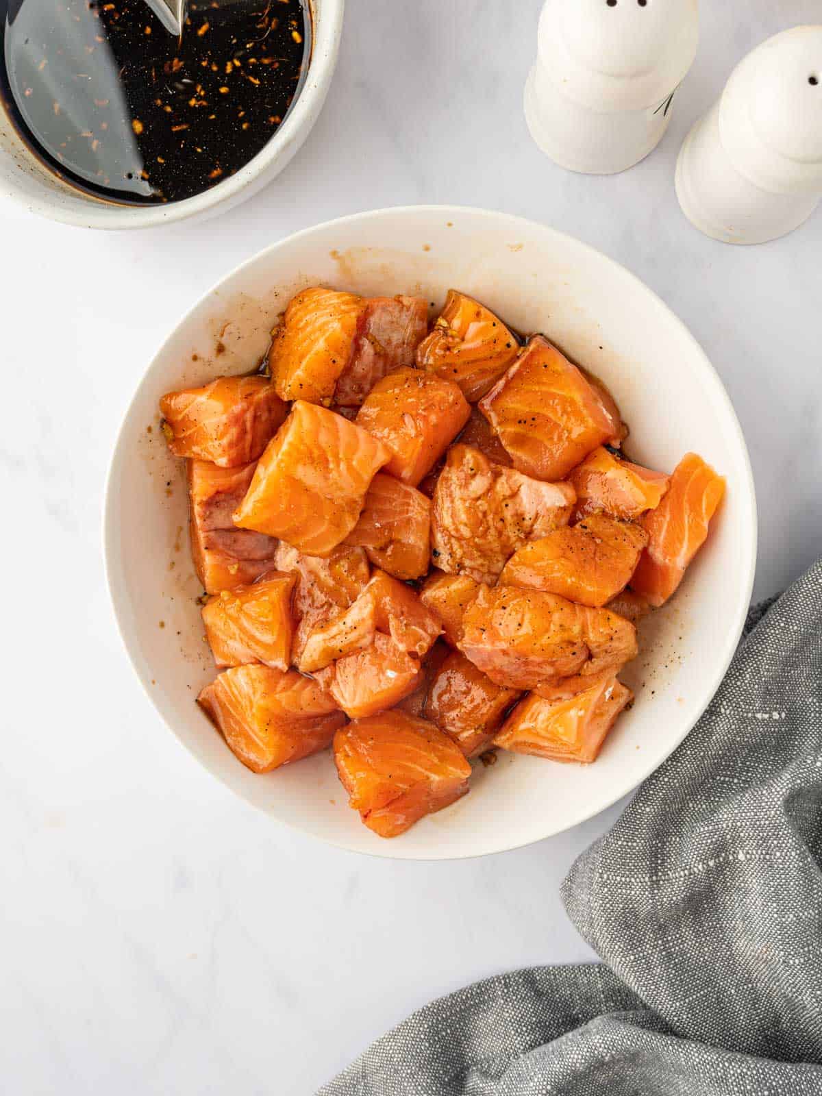 Seasoned cubes of salmon in a bowl.