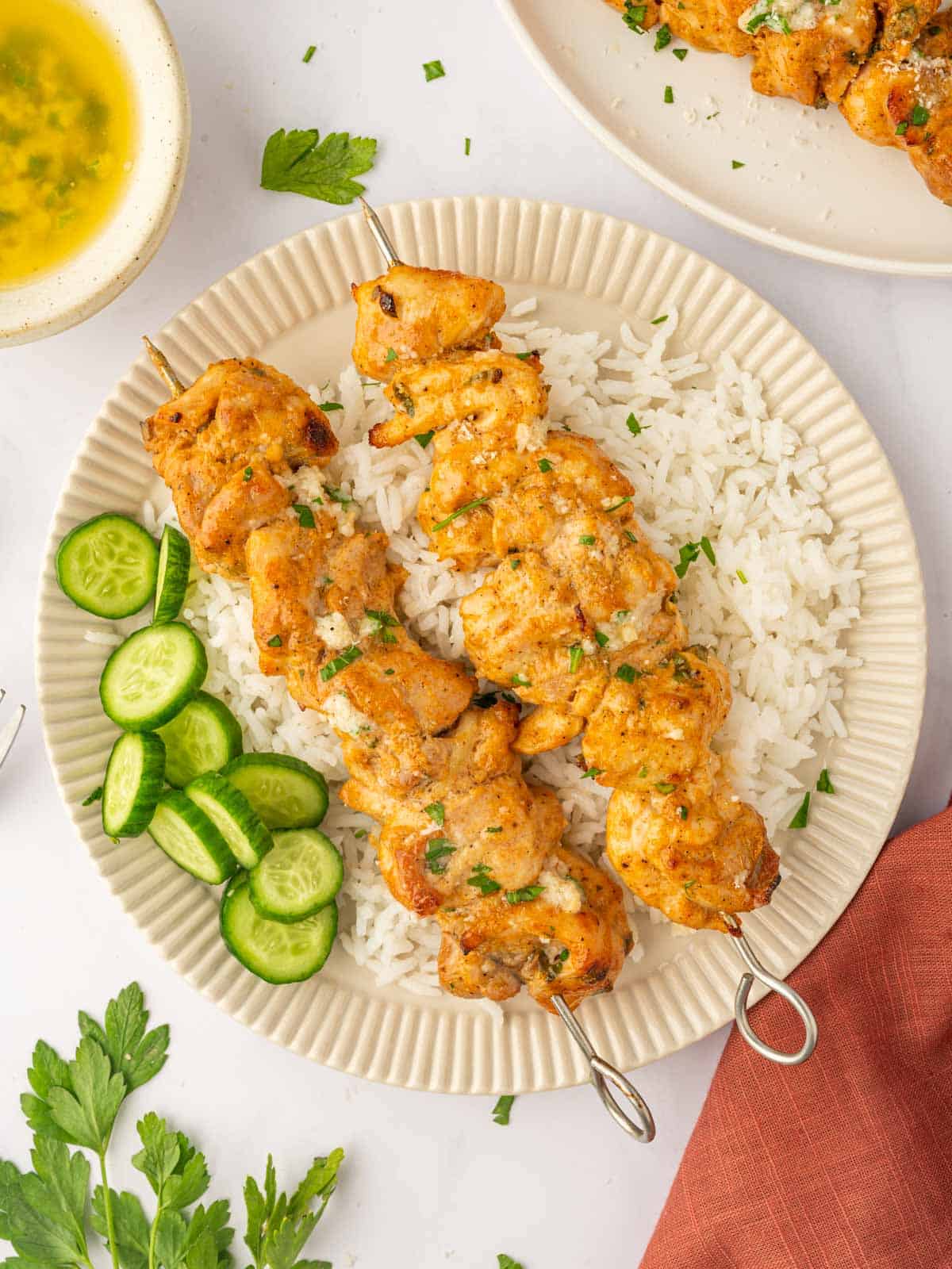 Oven chicken skewers with parmesan butter over rice.