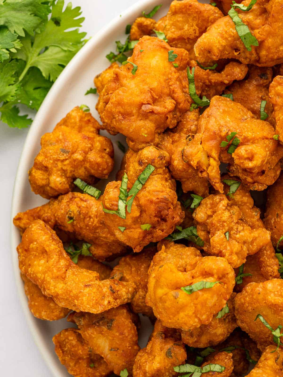 A closeup shot of chicken pakora on a platter.