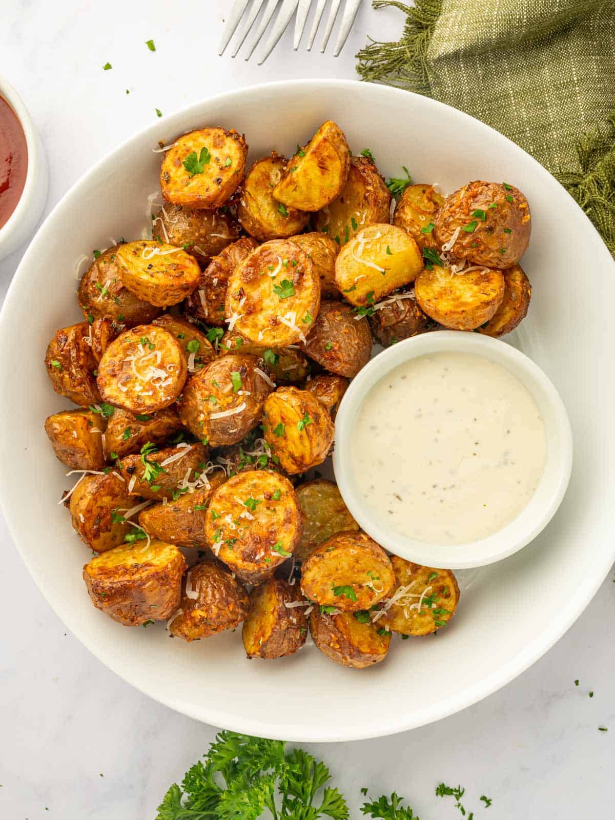 A platter of crispy air fried potatoes and dip.