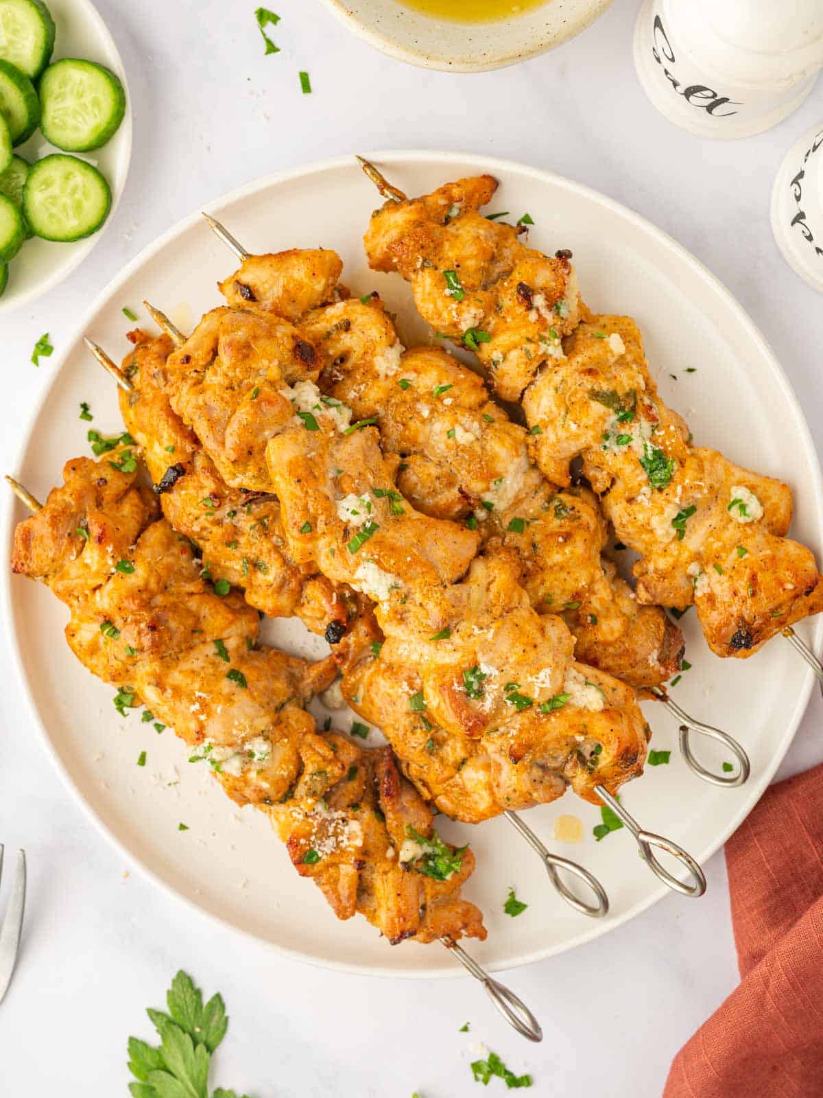 Baked chicken skewers on a platter.