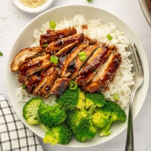 A single serving of Panda express teriyaki chicken on a plate with rice and broccoli.