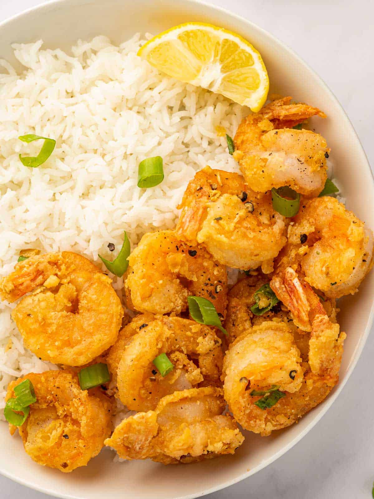 Crispy salt and pepper shrimp served with white rice on a plate.