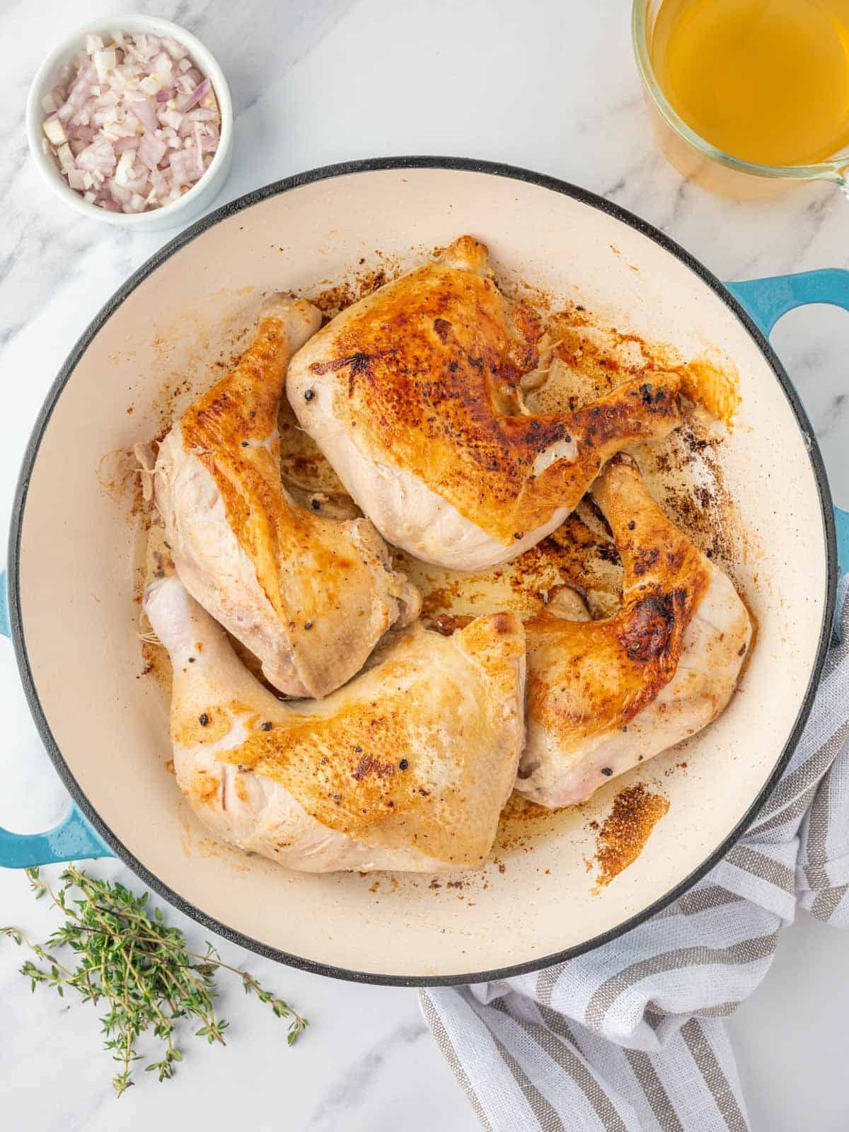 braised chicken legs in a skillet.