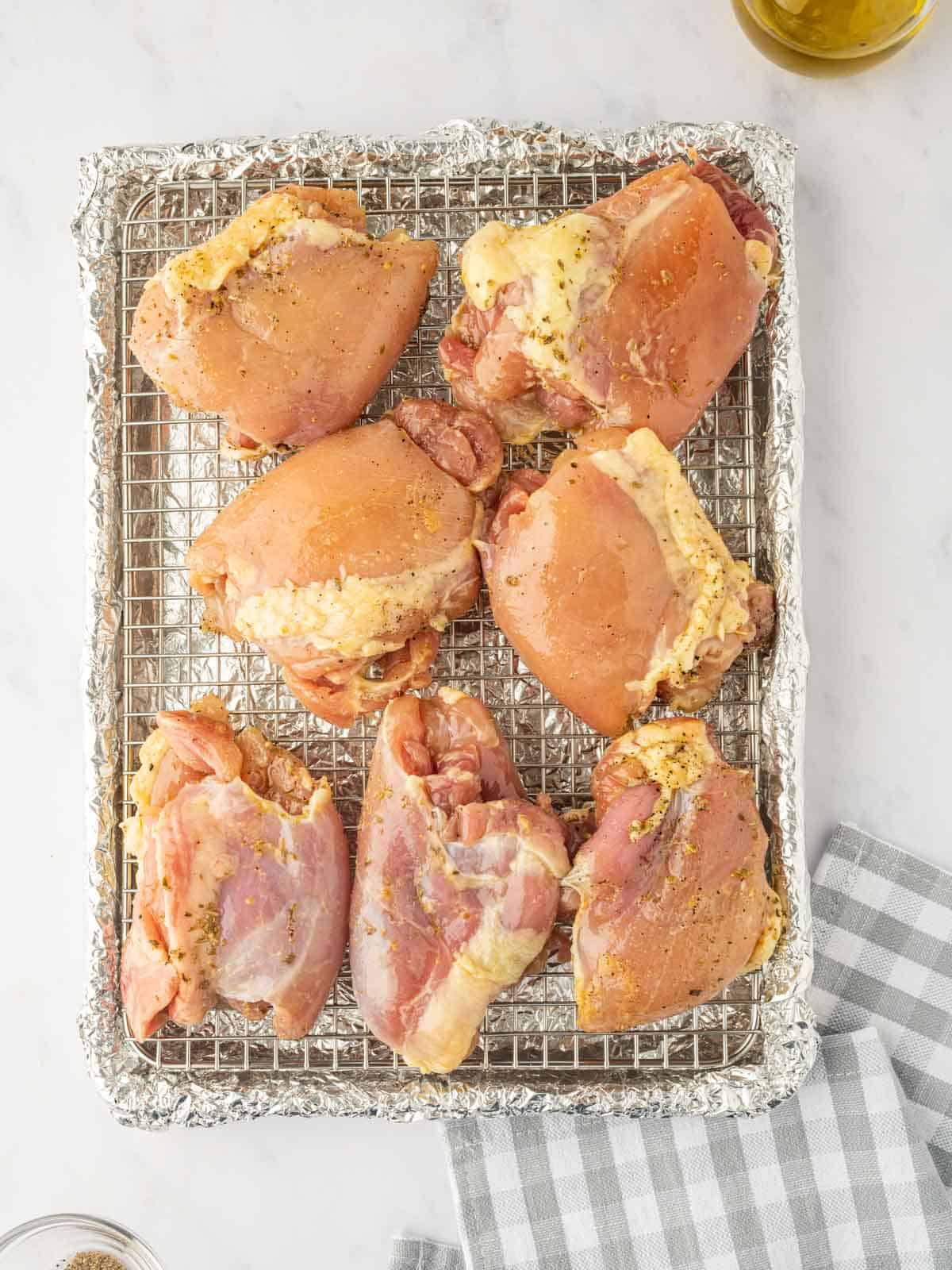Chicken thighs are arranged on a prepared baking rack.