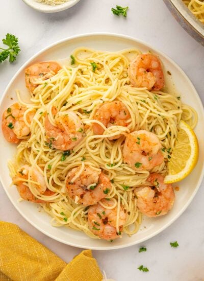 A plate with a serving of shrimp and pasta.