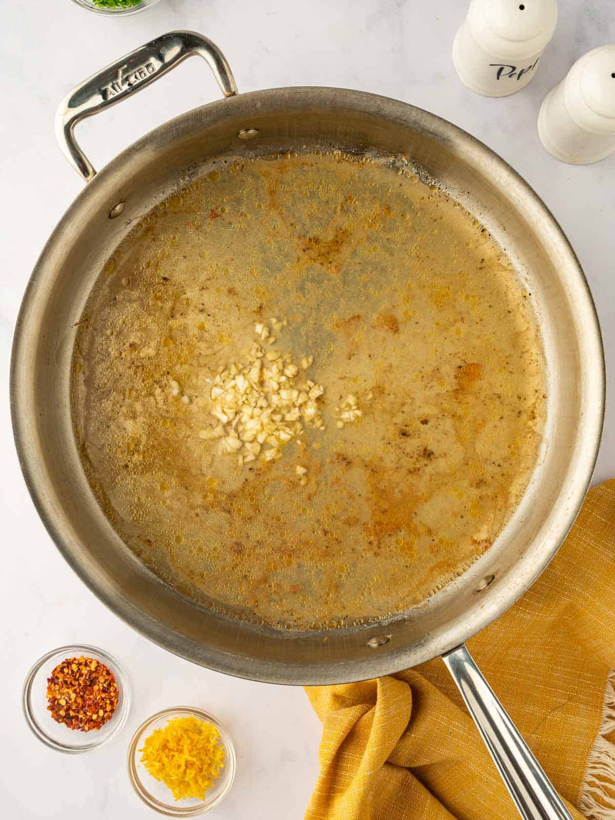 Preparing the scampi sauce in a skillet.