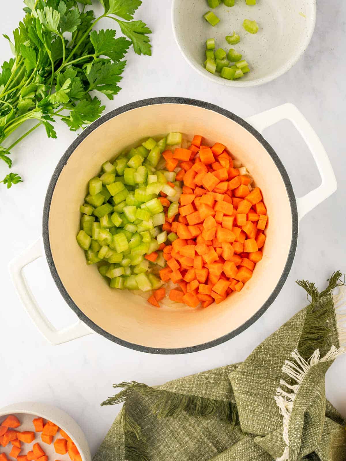 Celery and carrots are cooked in a dutch oven.