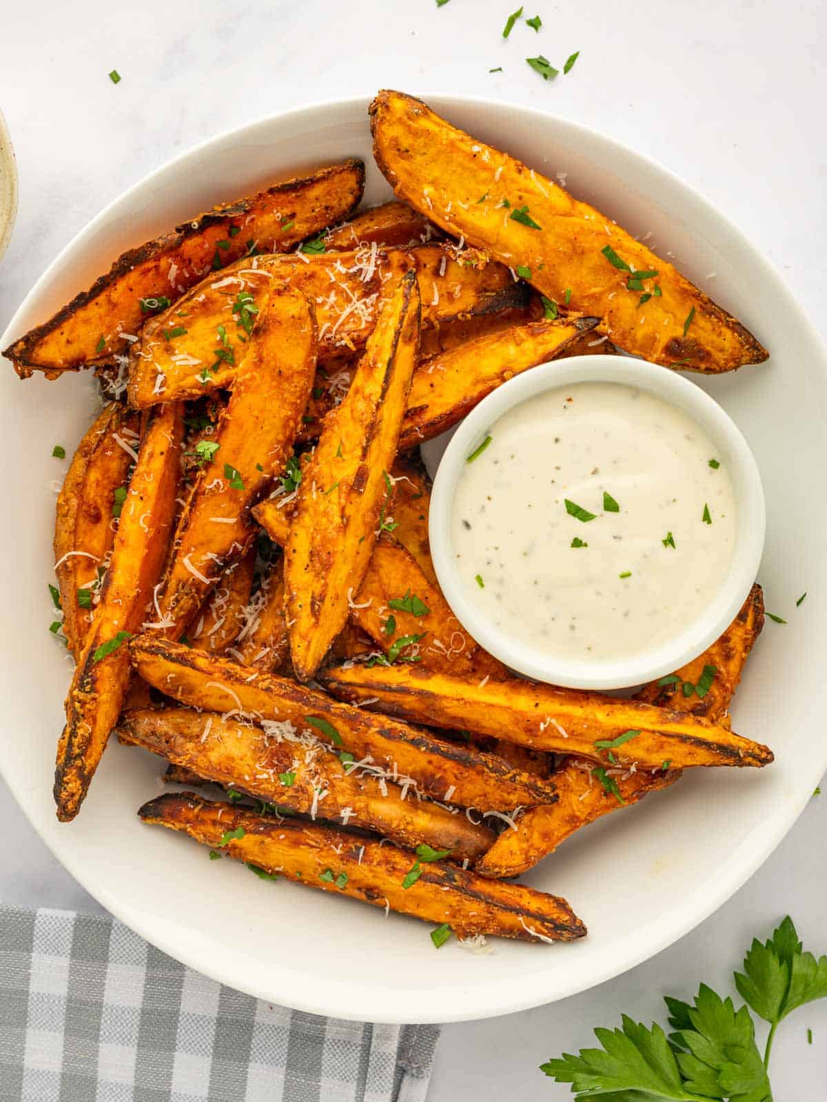 A bowl of sweet potato wedges with dipping sauce.