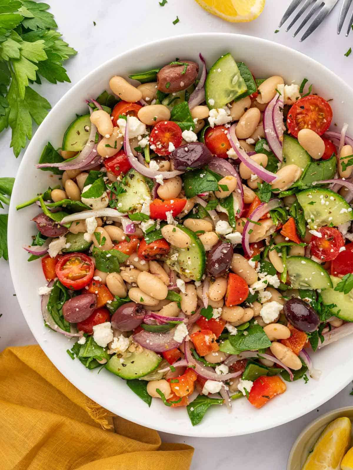 A large bowl of Mediterranean salad with beans and veggies.