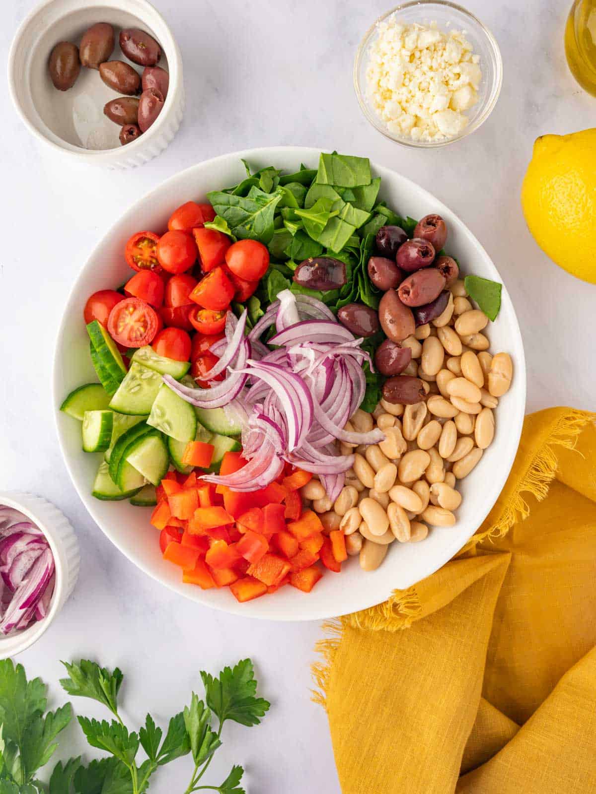 Ingredients for Greek bean salad are in a bowl.