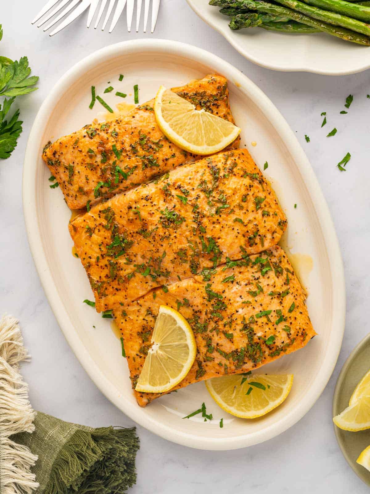 A tray of salmon with lemon pepper sauce.
