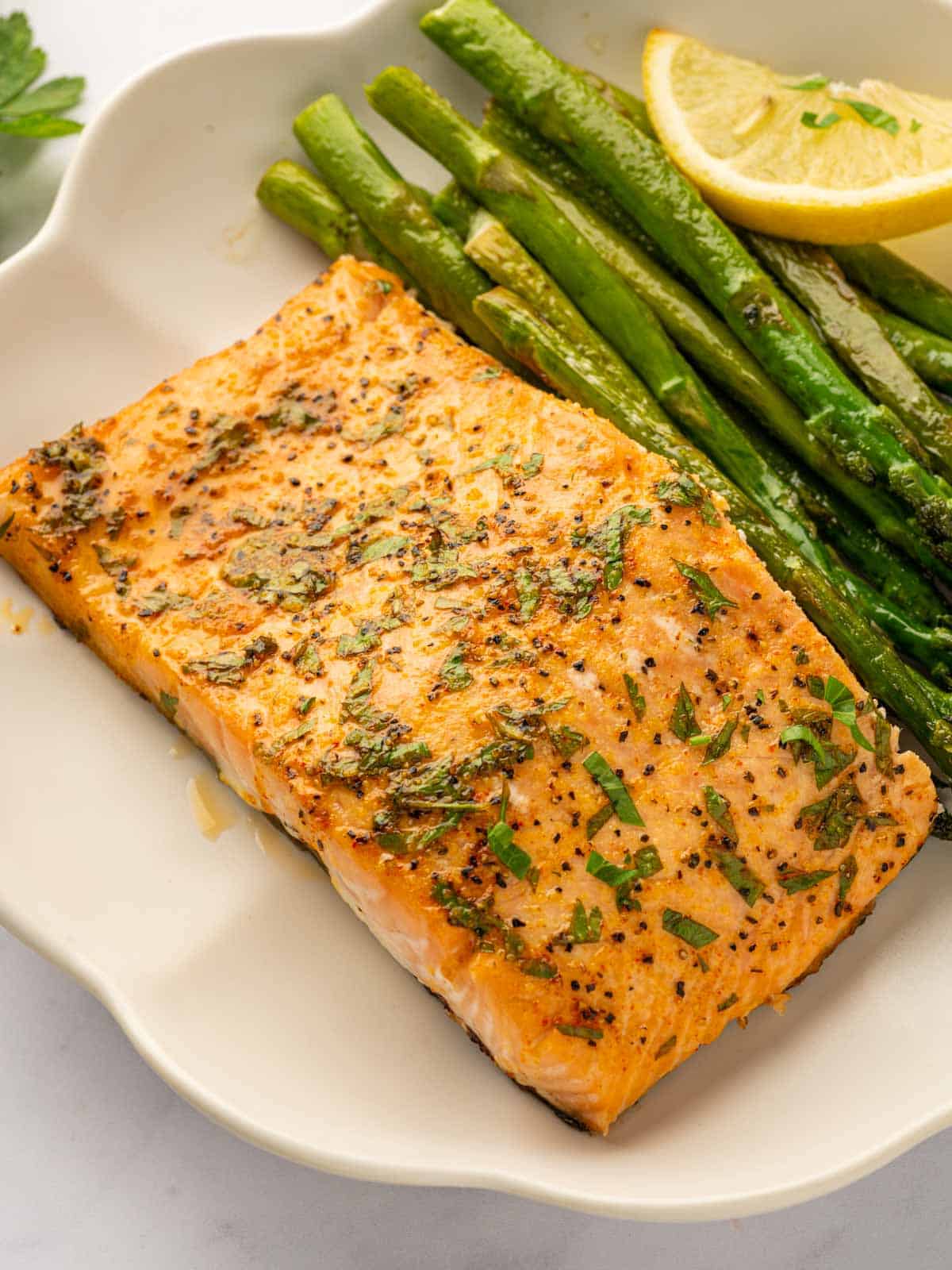 A plate with asparagus and a baked salmon filet.