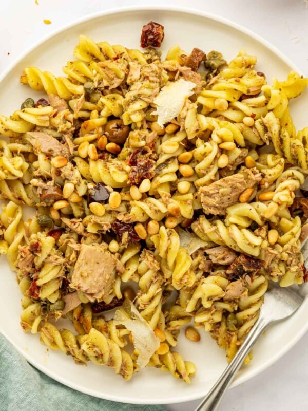 Pasta with tuna and pesto is on a plate with a fork.