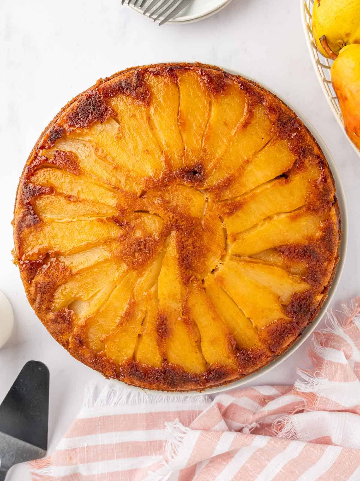 Whole pear upside down cake on a platter.