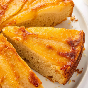 Slice of Upside Down Pear Cake with caramelized pears on top.