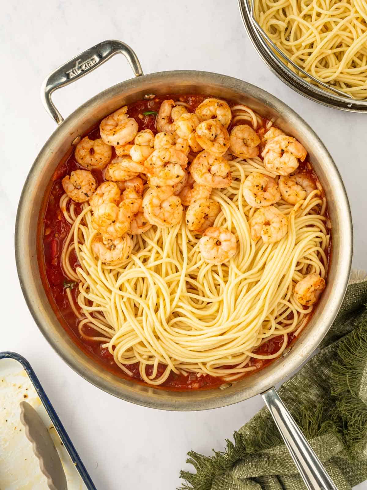 Combine the cooked pasta and shrimp with the sauce in the skillet.