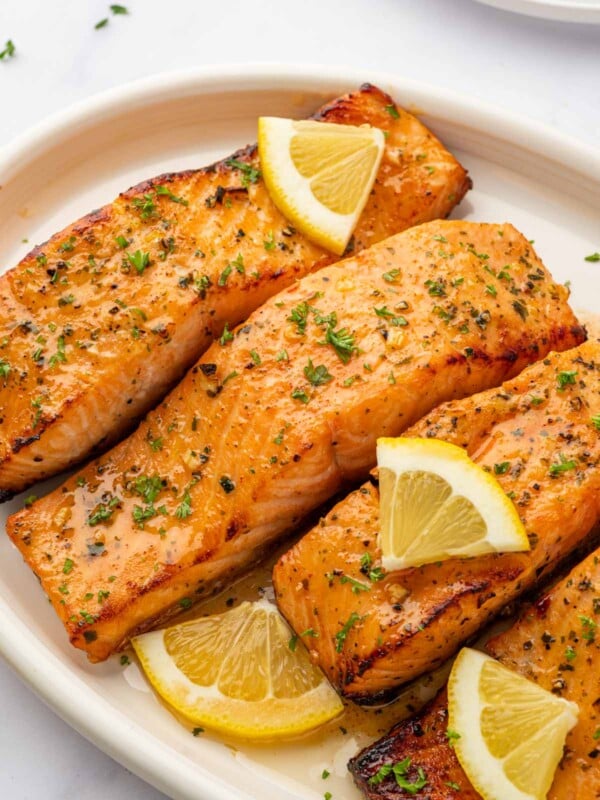 Air fried salmon filets on a platter with lemon slices.