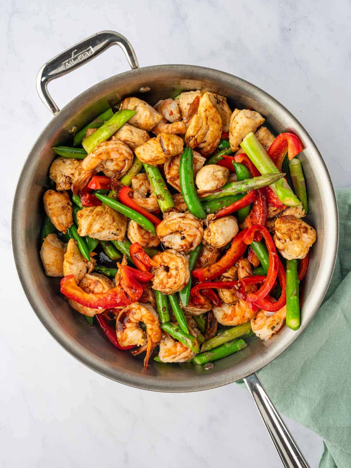 Chicken, shrimp and veggies in a skillet.