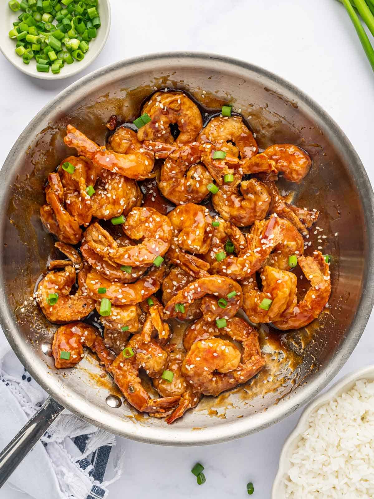 Shrimp in a skillet coated with honey sauce.