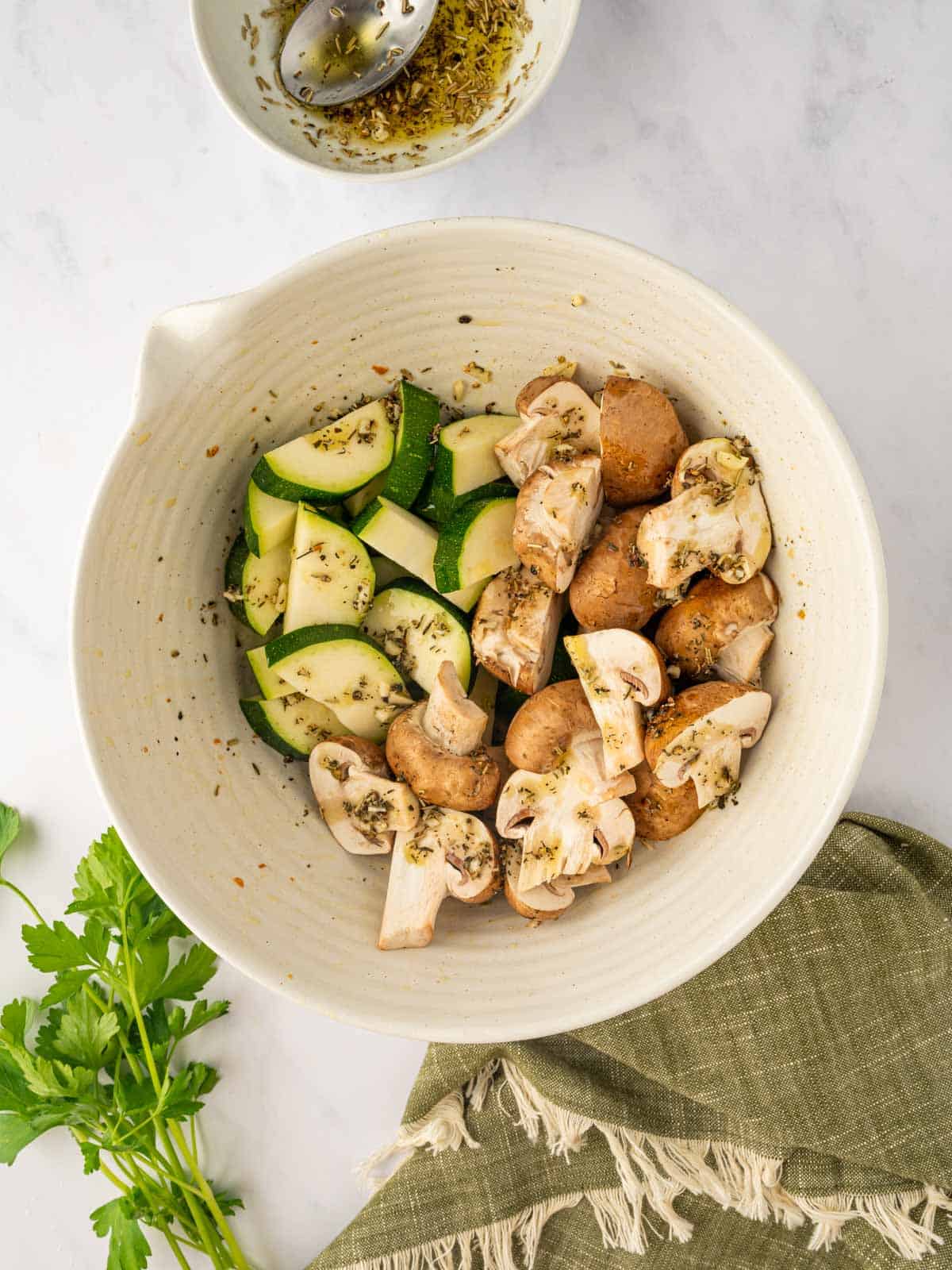 Seasoned zucchini and mushrooms in a bowl.